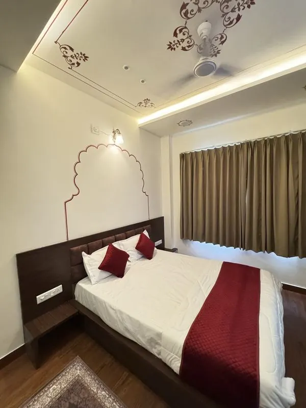 A room with a painted arch, a wide window and a softly lit ceiling