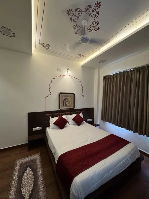 A room with a painted arch, framed miniature and motif-painted ceiling