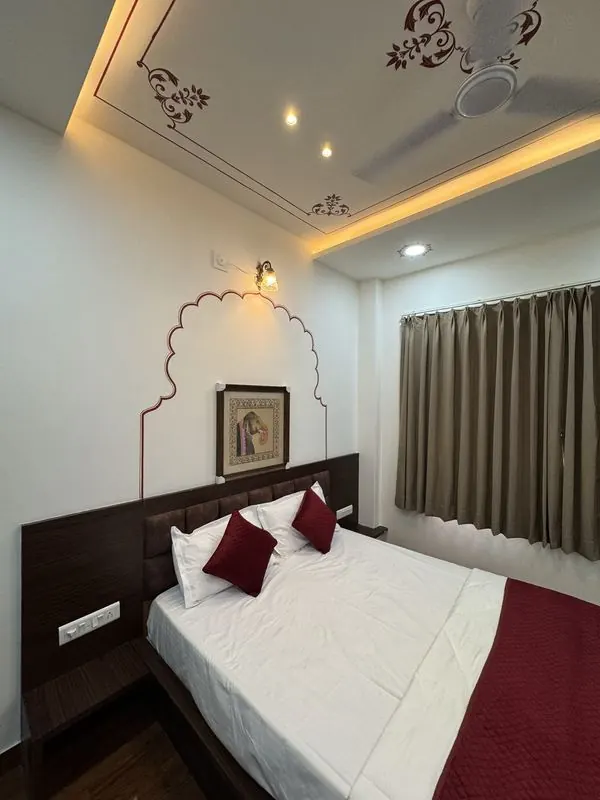 A framed miniature above the bed under a painted arch